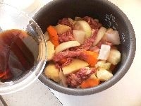 野菜類と牛肉を炊飯器に入れ、釜を上下にゆすって混ぜ、みりん以外の調味料を入れる。