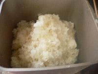 ホームベーカリーの内釜を水で濡らし、羽根がついてるのを確認して、蒸し上がった米を入れる。