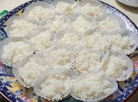 米は炊く30分前にといで、炊飯器に入れ、すし飯用に水加減し、のれんのように切り込みを入れた昆布を入れて炊く。 酢、砂糖、塩、酒をあわせておき、炊き上がったご飯に混ぜてさまし、 紙パックに盛り分けて大皿にのせ、白ごまをふる。