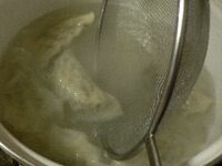 餃子が浮いて皮が透き通るような感じになったらすくい取り、水気を切って、一人分ずつ器に入れ、白髪ネギを天盛りする。