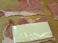 豚肉を半分に切り、両面に塩コショウをする。スライスチーズ1枚を半分に切り、豚肉ではさむ。<br />