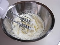 柔らかくなったバターをハンドミキサーでクリーム状に練り、砂糖を3回に分けて混ぜ合わせます。