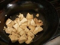 フライパンが汚れてたらペーパーで拭き、油を足して、手でちぎった豆腐を入れて焼きつける。