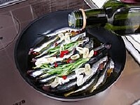 鍋に重ならないようにイワシをきっちり並べます。塩、コショウ少々を振りかけ、ニンニク、赤唐辛子、ローズマリー、オリーブオイルをイワシをかぶるくらい入れます。