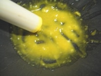 すり鉢にニンニクを入れ、すりつぶします。ニンニクがなめらかな状態になったら、卵黄を加え、軽く混ぜます。
