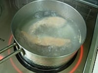 鮭そぼろを作ります。鍋に湯を沸かし鮭を茹でます。茹で上がったら骨と皮をとり、キッチンペパーで水気を取り除きながら身をほぐします。