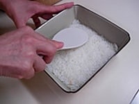 すし飯を器にいれ強く押し付けるように平らにご飯を押し付けます。