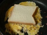 パンの切り込みした方を上にして、卵の上にのせ、軽く押しつける。