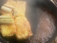 豆腐を片側に寄せ、空いた所にタレを注ぎ入れて一煮立ちさせてから、豆腐を真ん中に戻してからめる。