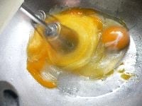手を長い間入れていられないくらいの温度のお湯で湯煎しながら、ハンドミキサーで卵とグラニュー糖（または砂糖）を泡立てる。