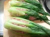 青梗菜の内側に小麦粉を薄くはたく。青梗菜の中心に挽き肉種を詰め、葉で包んで形を整える。