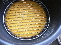 スイッチが切れたら内釜を取り出し、網か皿をケーキの上にのせ、釜を逆さにして取り出す。