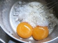 鍋に卵黄、薄力粉、砂糖をとって、泡だて器で混ぜる。