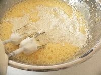 ふるっておいた小麦粉をふるいながら加え、ミキサーの低速で、ダマがなくなるまでよく混ぜ合わせる。