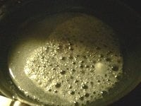 樹脂加工フライパンに砂糖と水を入れて中火にかけ、鍋をゆっくりまわして砂糖を溶かす。