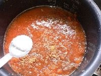 砕いた固形スープ、塩、ニンジン、ゴボウ、小女子を入れ、コショウを振り、炊飯スイッチを入れる。<br />