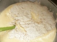 粉を広げて入れ、ボゥルを回しながら、ゴムベラで大きく混ぜる。