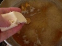 だし汁を加え、砂糖、塩、なめこを入れ、豆腐を手でつぶして入れる。