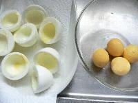 固ゆで卵の殻をむき、白身だけに切り目を入れて半分にし、白身と黄身とに分ける。白身はクッキングシートの上に置いて、水気を切っておく。