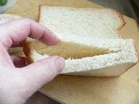 食パンを縦に半分に切り、切り口を薄く切り取ってから、中にナイフを差し込んで袋状にする。