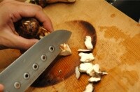 松茸は汚れを濡らしたクッキングペーパーなどでふいてよく取り除き、の石づきを、エンピツを削るようにして取る。<br />