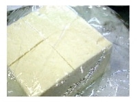 豆腐は4つ切りにし、耐熱容器に入れラップをかけ600Wで2分加熱して、水気を切る。<br />