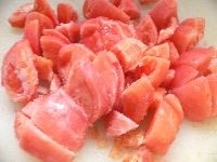 玉ねぎ、にんにくをみじん切り。冷凍トマトは水に浸けて皮をむき、角切りにする。
