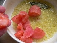 トマトを入れ、固形スープを手で砕いて加え、塩を1つまみ、コショウ少々を加えて混ぜ、ラップなしで、電子レンジ（600W ）で8～11分加熱する。