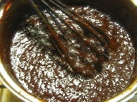 一度鍋を火から下ろし、味噌、しょうがとりんごのすりおろしを加えて泡立て器でよく混ぜ、ペースト状にします。
