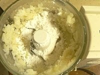 フードプロセッサーにじゃが芋を入れて砕く（7～8秒）。次に片栗粉と小麦粉を加える。<br />