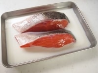 バットに鮭の切り身を並べ、牛乳を加えて15分程おきます。<br />