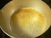 鍋に砂糖と水を入れて強火にかける。煮詰まってきて、焦げ色が少しでもついてきたら弱火にする。ゆっくり鍋を回して、全体的にカラメル色になったら火を止める。すぐに、左手で鍋を持ち、右手で湯大さじ2を加え、手に持った鍋を大きくすばやくグルグルまわして溶きのばす。<br />