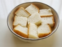 食パンを一口大に切り、耐熱皿に並べます。<br />
