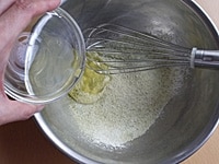 ふるった粉類に卵白を加え、全体が滑らかになり、卵白のこしがなくなって、粉っぽさがなくなるまでゴムべらでよく混ぜます。<br />
