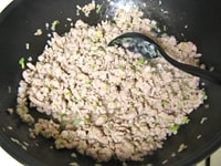 フライパンに油を入れ、中火にかけます。豚ひき肉を炒め、色が変わったら、長ねぎ、生姜を加え、さらに炒めます。<br />