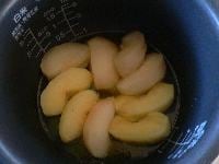 スイッチが切れたら、リンゴから出た汁（シロップ）を計量カップにあける。りんごと内釜が冷めるのを待つ。シロップに牛乳を足して180ccにする。