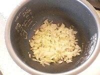 玉ねぎ、セロリ、にんにくはみじん切り。にんじんはすりおろす。干し椎茸は水で戻してみじん切り。生のトマトは皮を湯剥きするか、てっぺんの皮に十字に切り目を入れて、電子レンジで少し加熱して皮を剥く。内釜の底に、にんにくを敷き、その上に玉ねぎを入れ、オリーブオイルをかける。