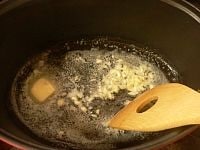 煮込み用の深鍋にバターを入れて火にかけ、ニンニクを炒めて香りを出す。<br />