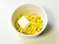 缶詰のコーンを耐熱皿に入れ、バターをのせます。 <br />