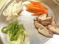 しいたけ、にんじん、青梗菜を細く切り、長ねぎを斜めに薄く切る。<br />