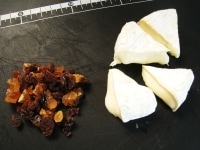 カマンベールチーズを一口大の扇型に切ります。ドライフルーツは粗みじん切りにします。<br />
