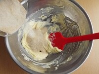 バターが白っぽいクリーム状になるまでゴムべらで練ります。さらにきび砂糖を加えて全体をよく混ぜます。<br />