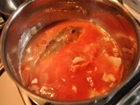ほうぼうとたらを入れて、トマト水煮缶の崩したトマトを加える。軽く塩をし、一煮立ちさせる。<br />
