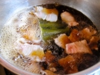 沸騰したら、豚肉を入れ、日本酒、醤油、塩を入れ、再沸騰したらていねいにアクを掬い取る。