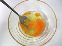 耐熱ボウルに卵を割りいれ、フォークで粗く混ぜます。ラップをふんわりかけ、600Wのレンジで約1分加熱します。
