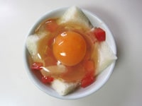 トマトの粗みじん切り、ベーコンの千切り、卵を割りいれます。卵の黄身を数か所、ようじでさします。