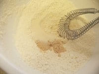 ボウルに小麦粉、ベーキングパウダー、砂糖、塩、ミルクを入れ、泡だて器でグルグル混ぜておく。<br />