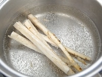 鍋にお湯を沸かし、酢を大さじ1/2加えたらごぼうを3分ゆでます。<br />