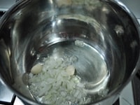 厚底鍋に、たまねぎのみじん切り、ニンニク、オリーブオイルを加え、中火にかける。