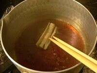 ごぼうを1つずつ鍋に入れて、たれをからめてバットに並べる。<br />